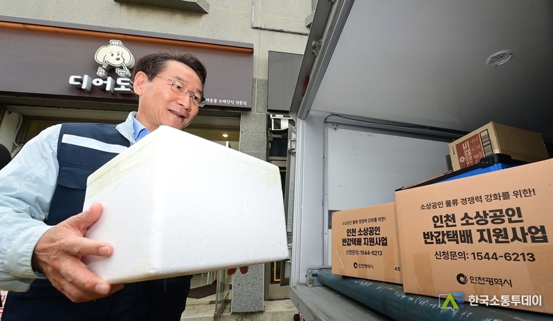 (사진촬영=인천시청 제공) 유정복 시장이 배송 물품을 차량에 싣고 있다.