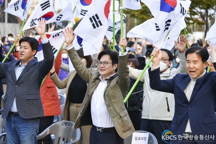김병수(가운데) 시장이 오라니장터를 찾아 양손에 태극기를 들고 주민들과 함께 만세 부르고 있다